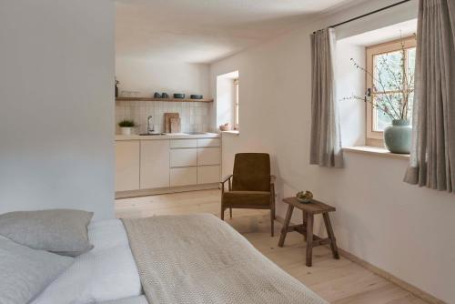 a bedroom with a bed and a chair and a window at Alpeltalhütte in Schönau am Königssee