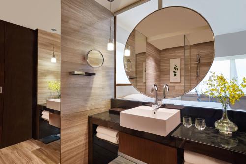 a bathroom with a sink and a mirror at Courtyard by Marriott Hong Kong in Hong Kong