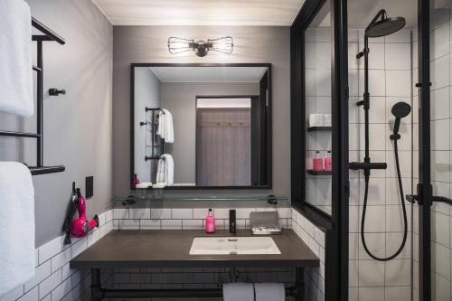 een badkamer met een wastafel en een spiegel bij MOXY Tokyo Kinshicho in Tokyo