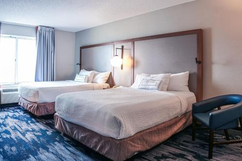Pokój hotelowy z 2 łóżkami i krzesłem w obiekcie Fairfield Inn and Suites by Marriott Indianapolis/ Noblesville w mieście Noblesville