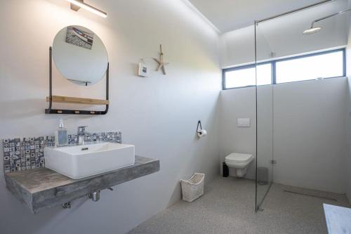 a white bathroom with a sink and a mirror at Pringle Bay getaway - 2 bedroom garden apartment in Pringle Bay