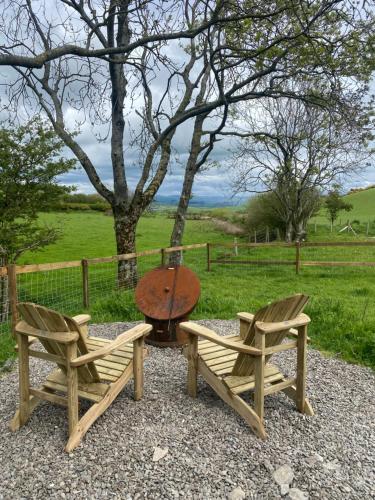 a table and two chairs and a table and a table and chairs at Silver Fern Glamping in Aberystwyth