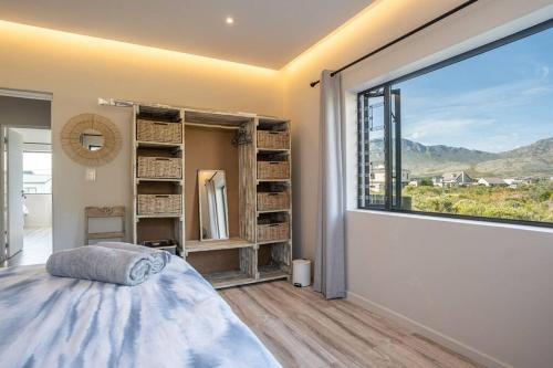 a bedroom with a large window and a bed at Pringle Bay getaway - 2 bedroom garden apartment in Pringle Bay