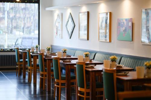 a row of wooden tables and chairs in a restaurant at Art Hotel Milano in Prato