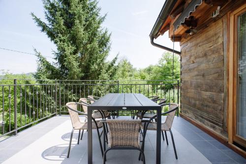 une table et des chaises sur le balcon d'une maison dans l'établissement Traditional houses Korana river, à Karlovac