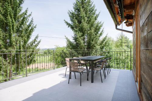 eine Terrasse mit einem Tisch und Stühlen auf dem Balkon in der Unterkunft Traditional houses Korana river in Karlovac