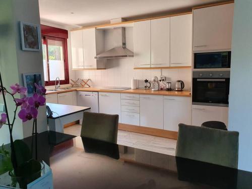 a kitchen with white cabinets and a table and chairs at Exclusive Villa in Benahavis in Estepona