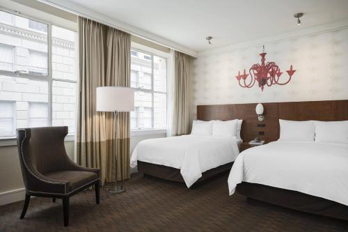 una habitación de hotel con 2 camas y una silla en Renaissance New Orleans Pere Marquette French Quarter Area Hotel en Nueva Orleans