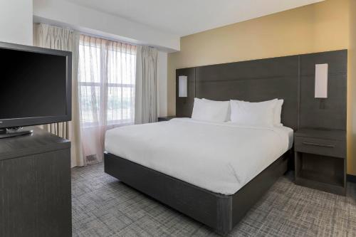 1 dormitorio con 1 cama grande y TV de pantalla plana en Residence Inn by Marriott Denver Golden/Red Rocks, en Golden