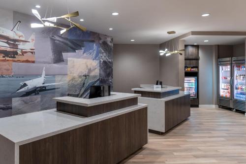 a restaurant with two counters and a painting of a plane at Residence Inn by Marriott Lancaster Palmdale in Lancaster