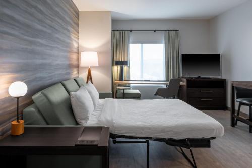 a hotel room with a bed and a desk at Residence Inn by Marriott Lancaster Palmdale in Lancaster