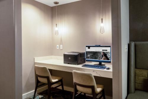 a room with a desk with a computer and chairs at Residence Inn by Marriott Denver Golden/Red Rocks in Golden