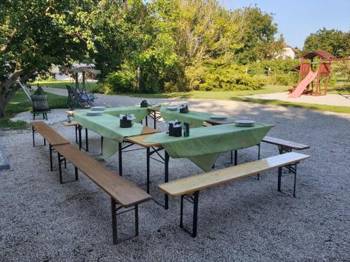 a group of picnic tables and benches in a park at Napvirág-Ház in Zsira