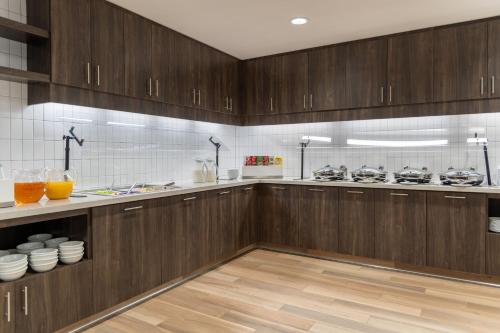 a kitchen with wooden cabinets and wooden floors at Residence Inn by Marriott Lancaster Palmdale in Lancaster