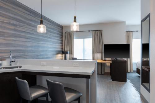 a living room with a kitchen with a counter and chairs at Residence Inn by Marriott Lancaster Palmdale in Lancaster