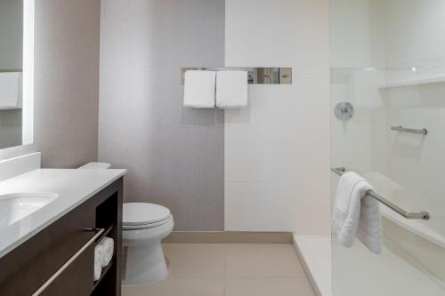 a white bathroom with a toilet and a shower at Residence Inn by Marriott Lancaster Palmdale in Lancaster