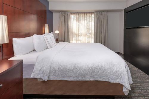 um quarto de hotel com uma cama grande e uma televisão em Residence Inn Mobile em Mobile