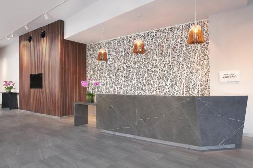 a lobby with a reception desk and two lights at Courtyard by Marriott Brisbane South Bank in Brisbane