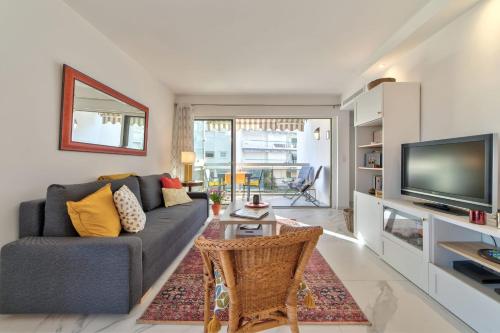 un salon avec un canapé et une télévision dans l'établissement Appartement Reina Pointe Croisette Palm Beach, à Cannes