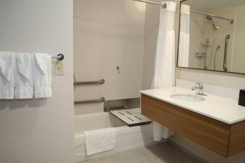 a bathroom with a sink and a tub and a mirror at Fairfield Inn by Marriott Hazleton in Hazleton