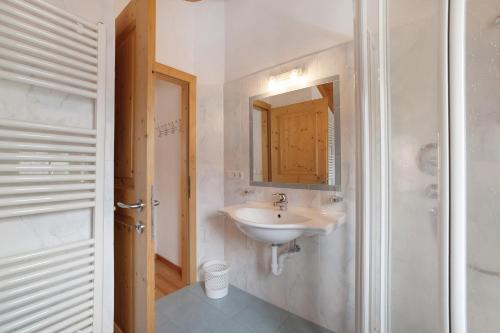 a white bathroom with a sink and a mirror at Ferienwohnungen Zwick Valmeina in Burgusio