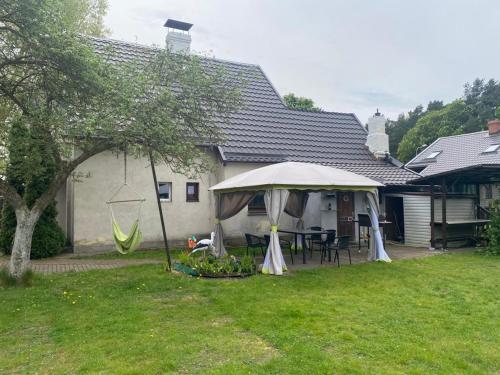 a backyard with a table and an umbrella at Svetes house - Garden & BBQ & Parking in Liepāja