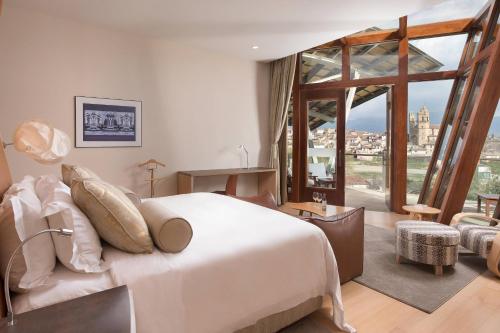 um quarto com uma cama branca e uma grande janela em Hotel Marqués de Riscal, a Luxury Collection Hotel, Elciego em Elciego