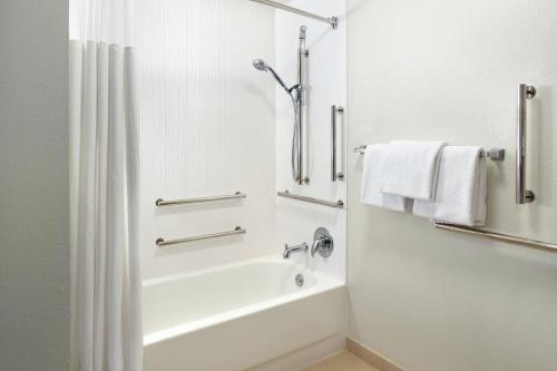 ein Bad mit einer Badewanne und einer Dusche mit Handtüchern in der Unterkunft Courtyard by Marriott Greensboro in Greensboro