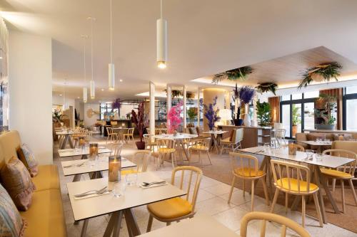 a restaurant with tables and chairs in a room at Riviera Marriott Hotel La Porte De Monaco in Cap d'Ail
