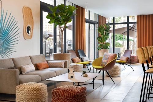 a lobby with a couch and chairs and tables at Riviera Marriott Hotel La Porte De Monaco in Cap d'Ail