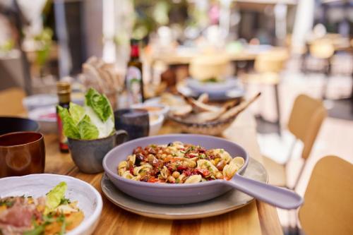 a bowl of food on a table with a plate of food at Riviera Marriott Hotel La Porte De Monaco in Cap d'Ail
