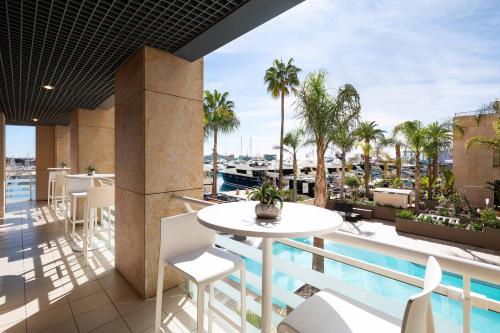 a balcony with a table and chairs and a pool at Riviera Marriott Hotel La Porte De Monaco in Cap d'Ail