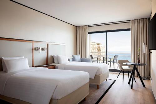a hotel room with two beds and a view of the ocean at Riviera Marriott Hotel La Porte De Monaco in Cap d'Ail