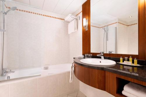 a bathroom with a tub and a sink and a bath tubermottermott at Riviera Marriott Hotel La Porte De Monaco in Cap d'Ail