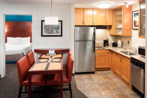 Una cocina con una mesa y una habitación con una cama. en Residence Inn by Marriott Dothan, en Dothan