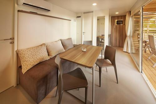 a living room with a table and a couch at Premium Mobile Homes - Hotel & Resort Adria Ankaran in Ankaran