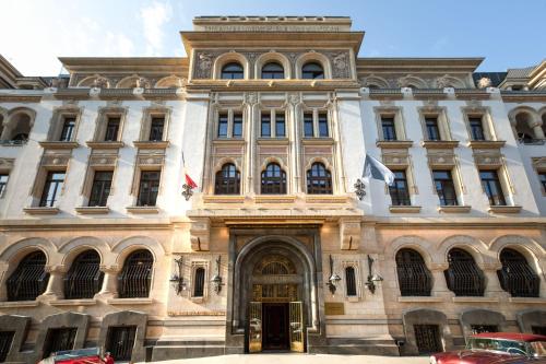 a large building with two flags in front of it at The Marmorosch Bucharest, Autograph Collection in Bucharest