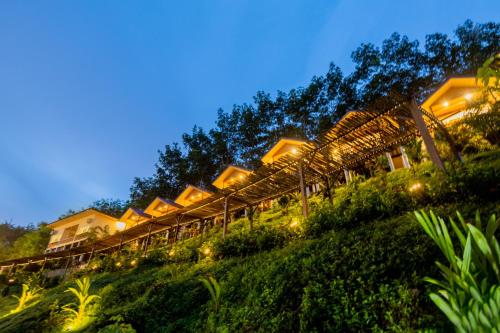 Una fila de lodges en una colina por la noche en Khao Sok River Home Resort, en Khao Sok