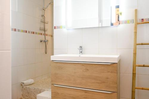 ein Bad mit einem Waschbecken und einem Spiegel in der Unterkunft Sur le port de Marseille ~ Hypercentre ~ La Criée in Marseille