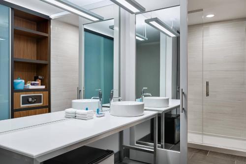 a bathroom with two sinks and a shower at Aloft Austin Northwest in Austin