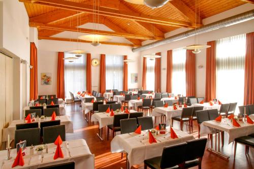 une salle à manger avec des tables et des chaises blanches dans l'établissement Morada Hotel Gothaer Hof, à Gotha