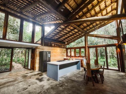 a kitchen and dining room of a house with windows at Chalés Vila Floresta in Alto Paraíso de Goiás