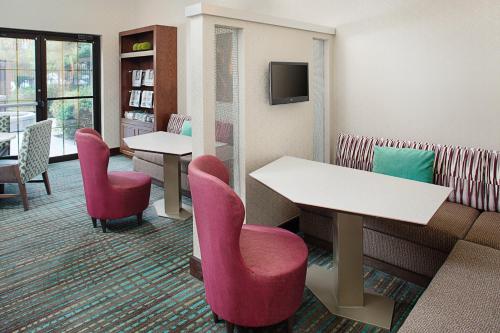 Pokój z dwoma stołami i krzesłami oraz telewizorem w obiekcie Residence Inn Dallas Addison/Quorum Drive w mieście Dallas