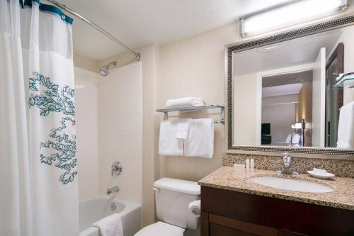 a bathroom with a sink and a toilet and a mirror at Residence Inn by Marriott Long Beach in Long Beach