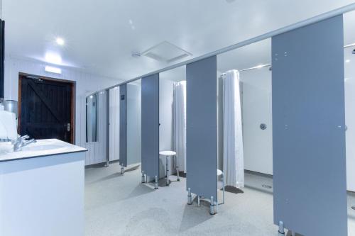La salle de bains est pourvue d'une rangée de lavabos et de miroirs. dans l'établissement Fairwood Lakes - Shepherd's Hut with Hot Tub, à North Bradley