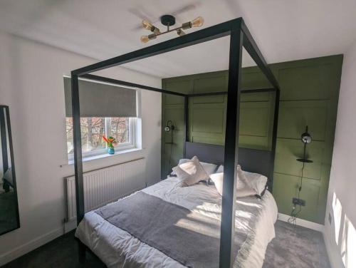 1 dormitorio con cama con dosel y ventana en Cottage/boutique style - Free parking & Wi-Fi en Hull