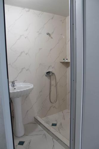 ein Badezimmer mit Dusche und Waschbecken in der Unterkunft Tokaplus in Batumi