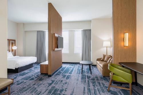 een hotelkamer met een bed, een bank en een tv bij Fairfield Inn & Suites by Marriott Des Moines Downtown in Des Moines