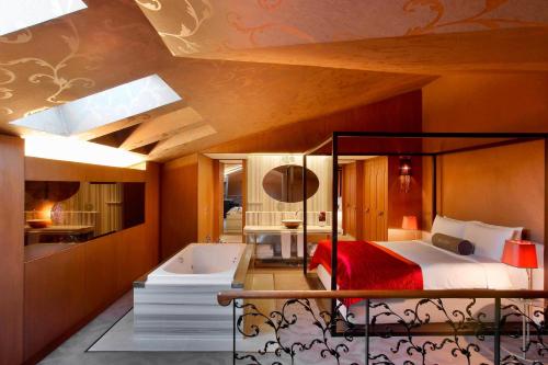 a bedroom with a bed and a bathtub and a bed and a bathroom at W Istanbul in Istanbul