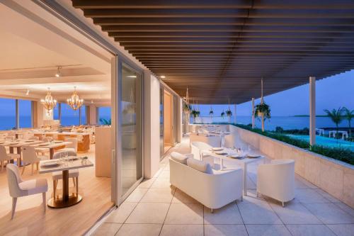 a restaurant with white furniture and a view of the ocean at IRAPH SUI, a Luxury Collection Hotel, Miyako Okinawa in Miyako Island